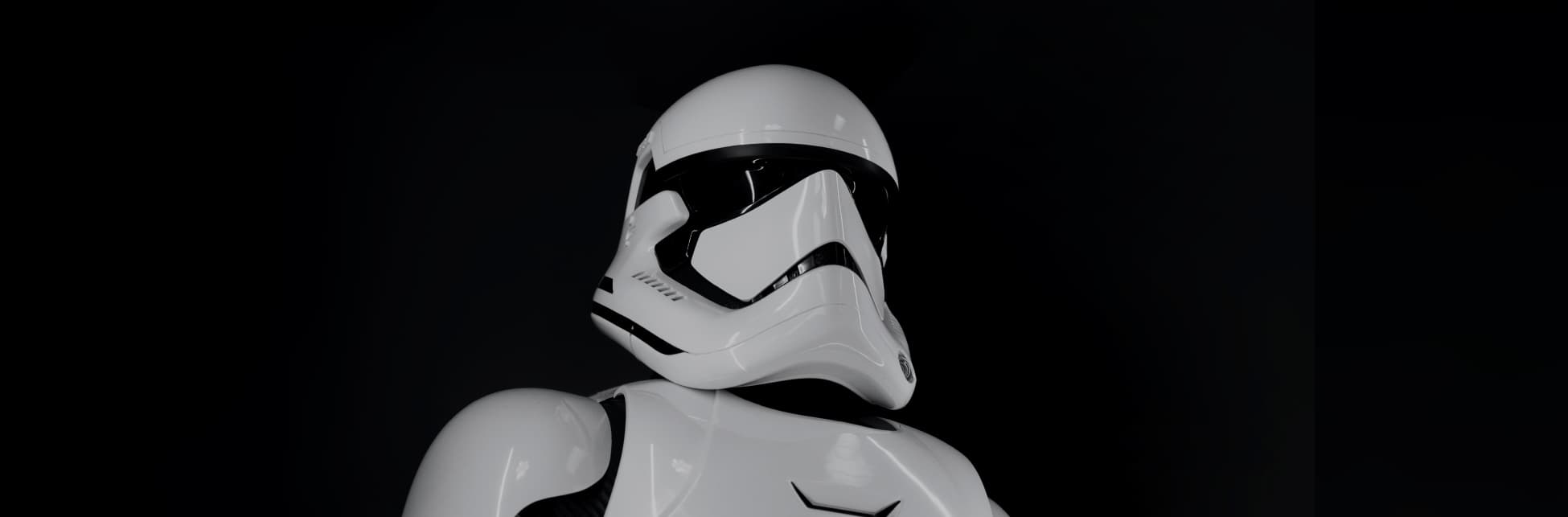 Foto. En el centro de la imagen una figura de medio cuerpo cubierta por una armadura blanca, tiene en la cabeza un casco blanco y grande. 