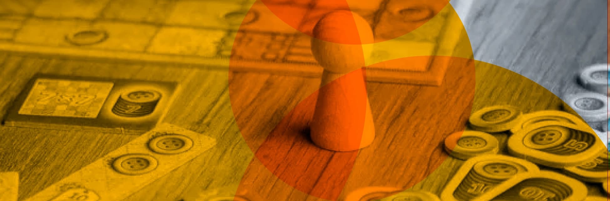 Fotografía. Sobre una mesa con fichas, cartas y un peón de juego en primer plano, se superponen formas circulares translúcidas.