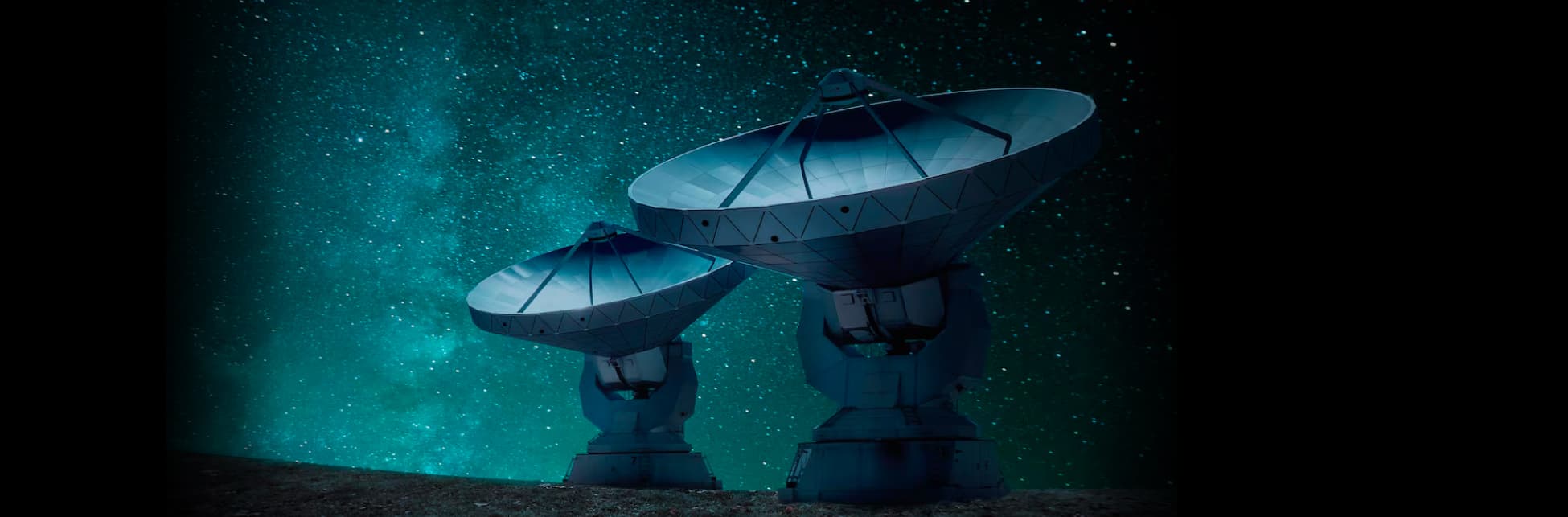 Foto. Sobre un fondo estrellado aparecen dos antenas gigantes metálicas, dos plataformas que en la punta tienen un objeto similar a un cono que apunta hacia el cielo.
