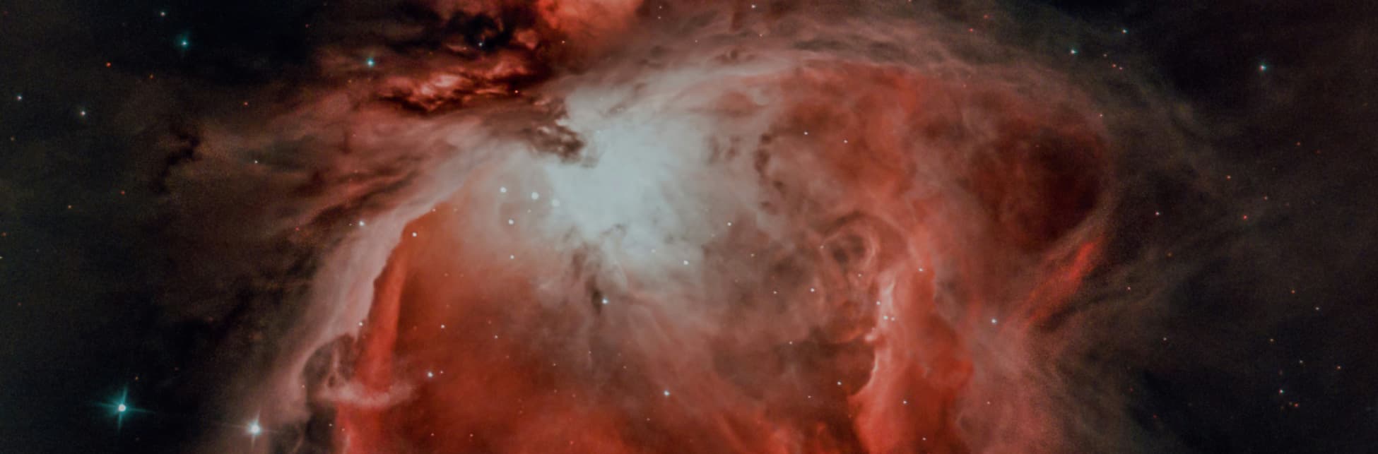 Fotografía. Sobre un fondo negro con estrellas blancas se observa una nube rojiza y blanca.