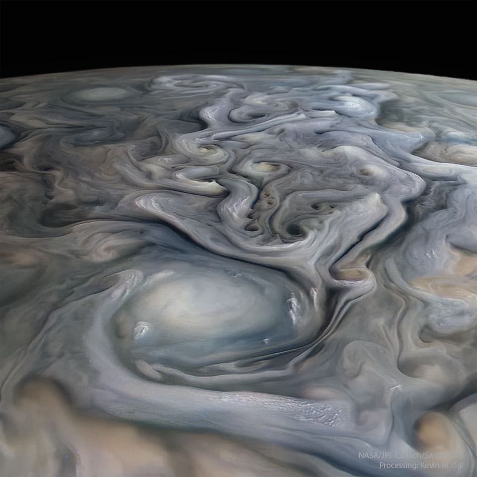 Foto. remolinos de nubes grises y blancas en la superficie de un planeta. Se ve su curvatura y en la parte superior un fondo negro.