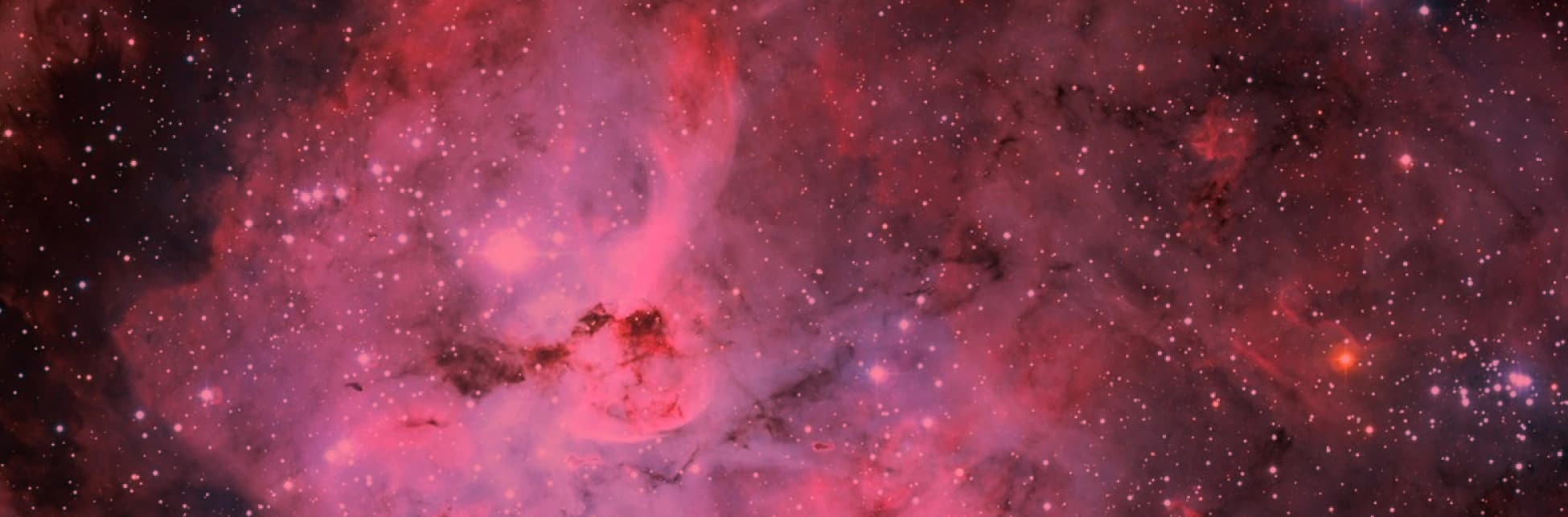 Fotografía astronómica. Un fondo de nebulosa en tonos rosados y morados con estrellas.