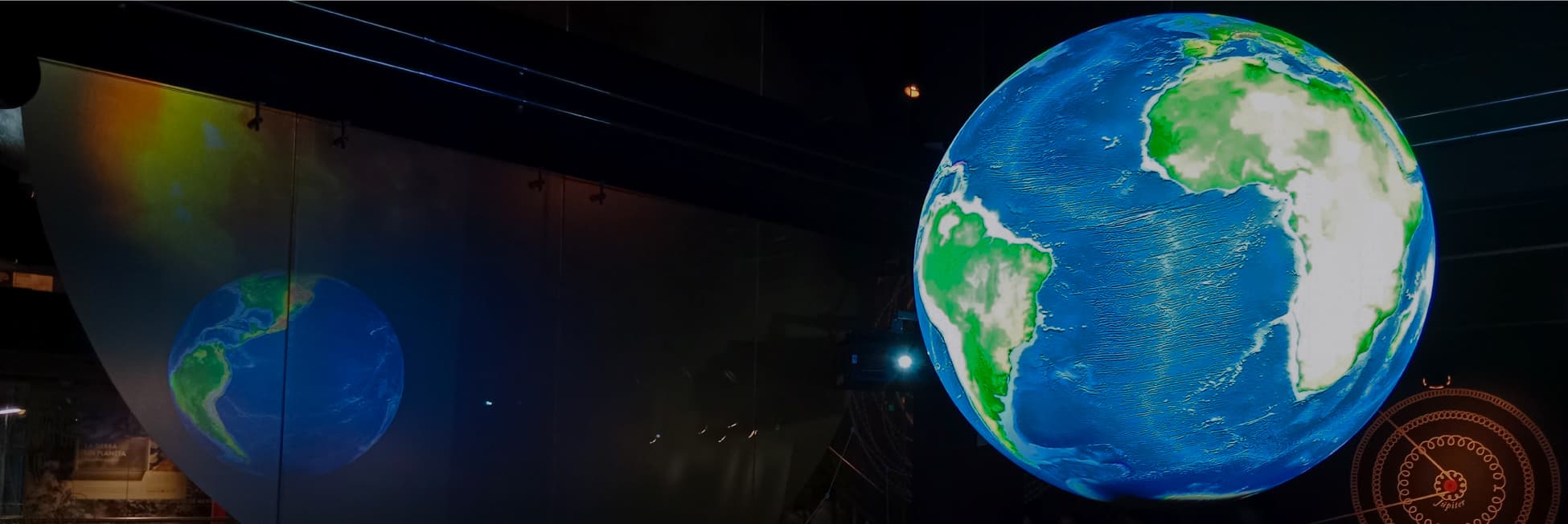 Foto. En la parte derecha de la imagen un globo terráqueo, una esfera azul con zonas verdes de tierra.