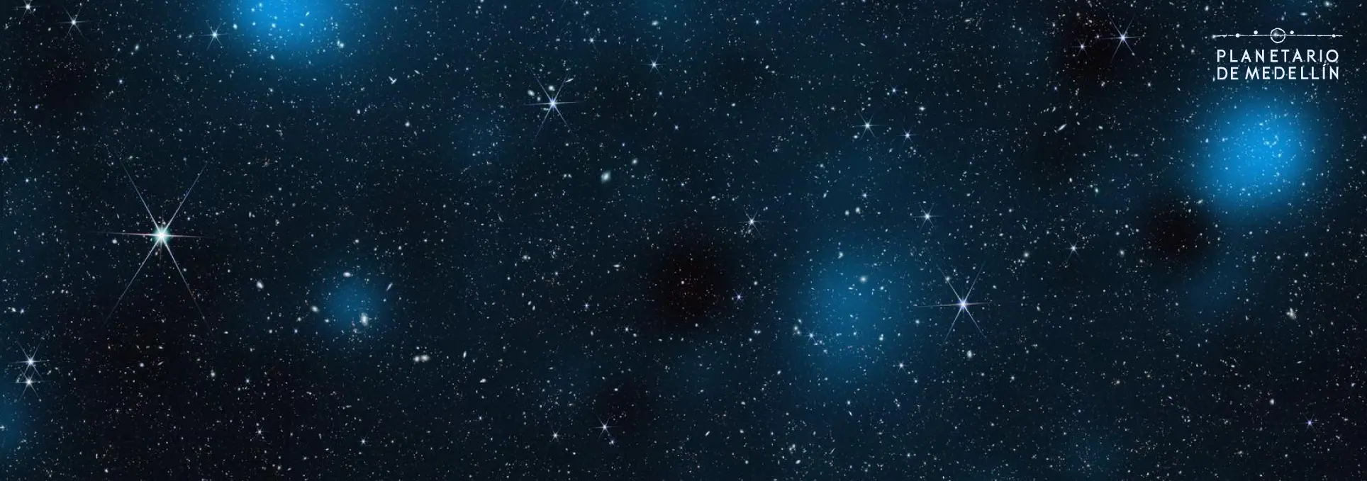 Fotografía de un campo estelar con numerosos puntos luminosos y nebulosidades.