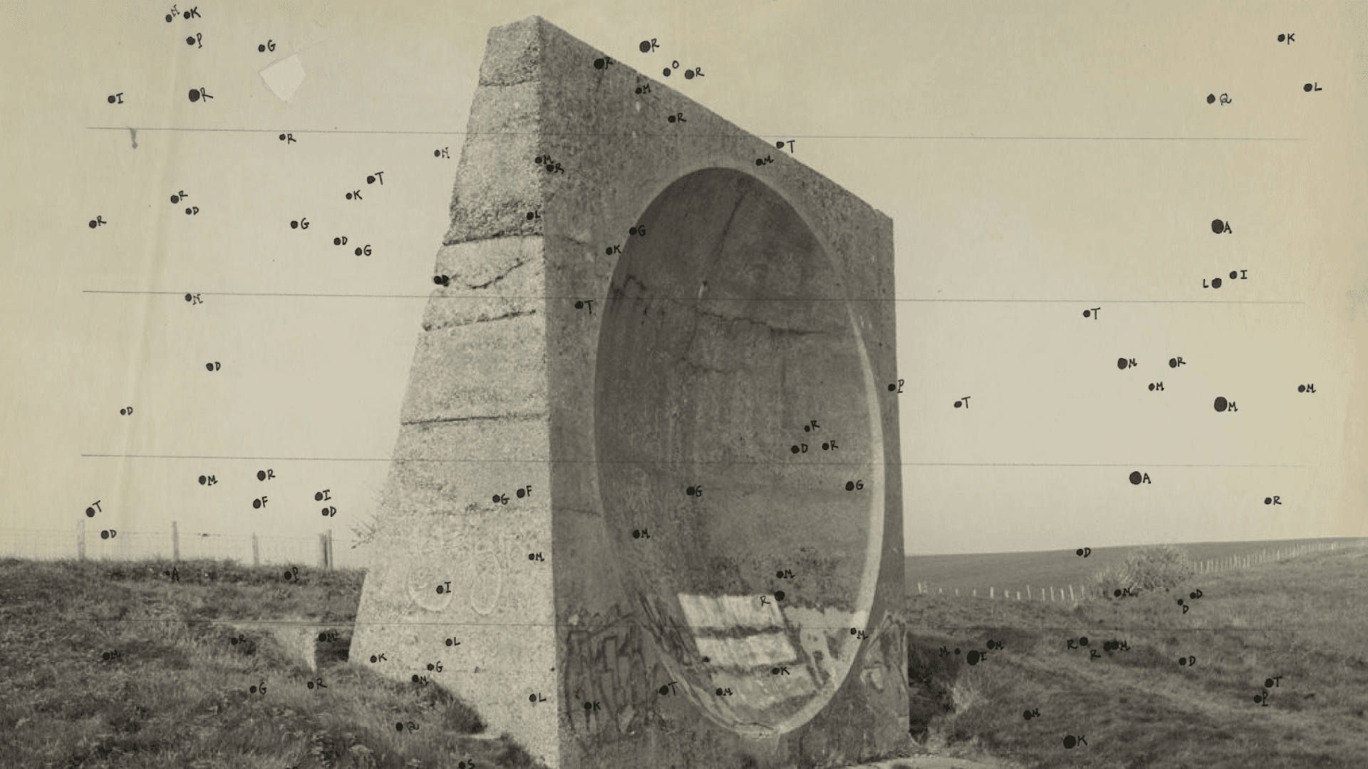 Forografía. En un paisaje rural, se erige una escultura de piedra que simula un inmenso parlante. Sobre la imagen, múltiples puntos negros dibujados.