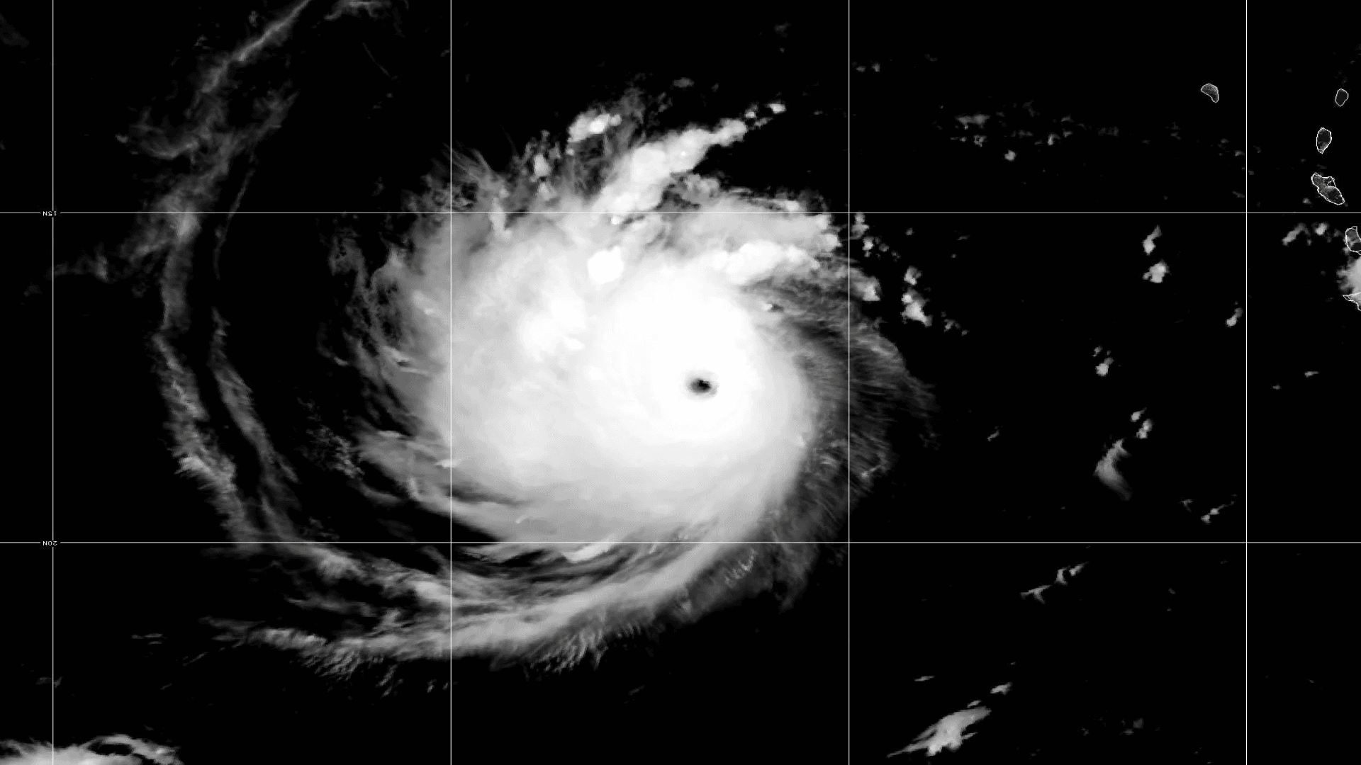 Ilustración. Sobre un fondo negro, se observa una imagen satelital en blanco y negro de un ciclón tropical; se distingue su estructura circular con un ojo en el centro. La imagen está dividida por líneas finas blancas que forman una cuadrícula.