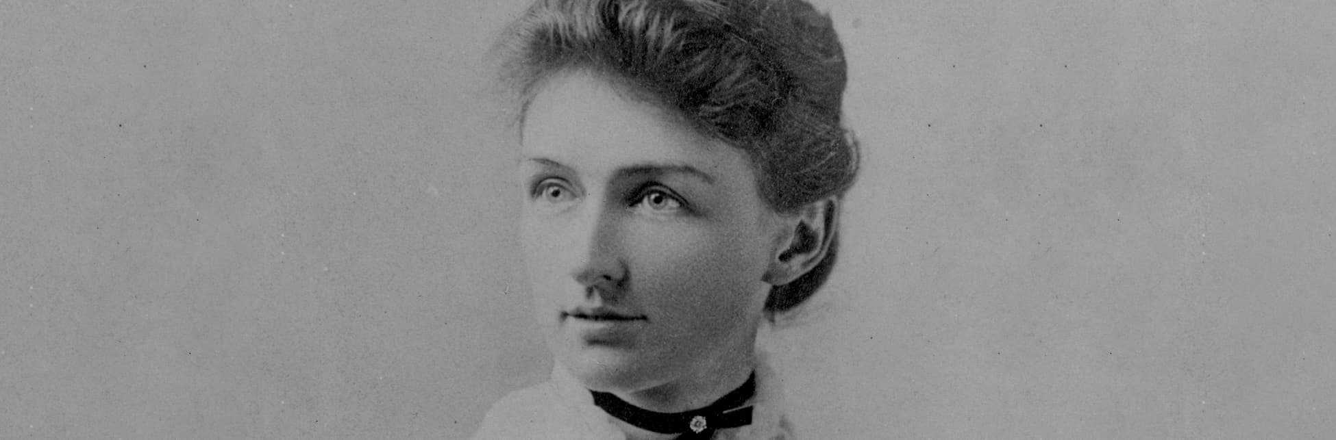 Fotografía. Rostro de Annie Jump Cannon, con cabello recogido, cejas delgadas, labios pequeños y ojos brillantes. En el cuello lleva collar en forma de lazo color negro y una camisa con boleros.