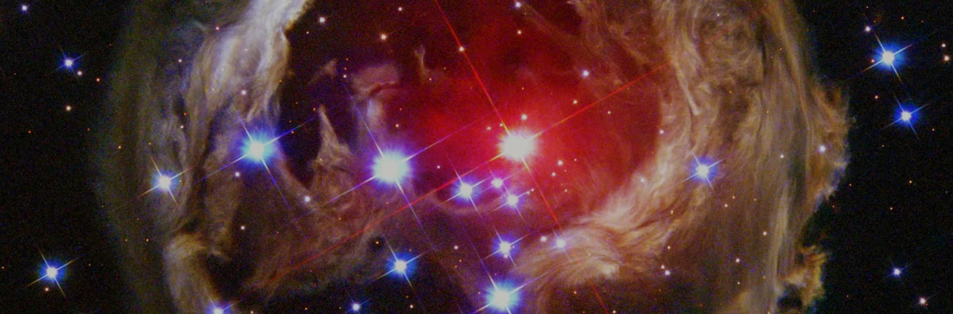 Astrofotografía. Destellos de diferentes tamaño envueltos en una nube.