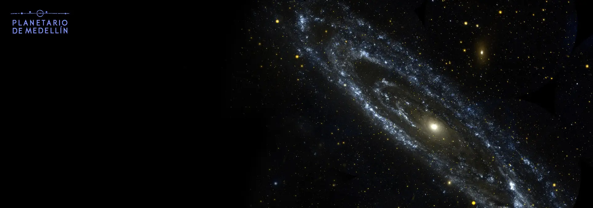 Fotografía astronómica. Sobre un fondo negro con estrellas, en el centro aparece una galaxia alargada en diagonal.