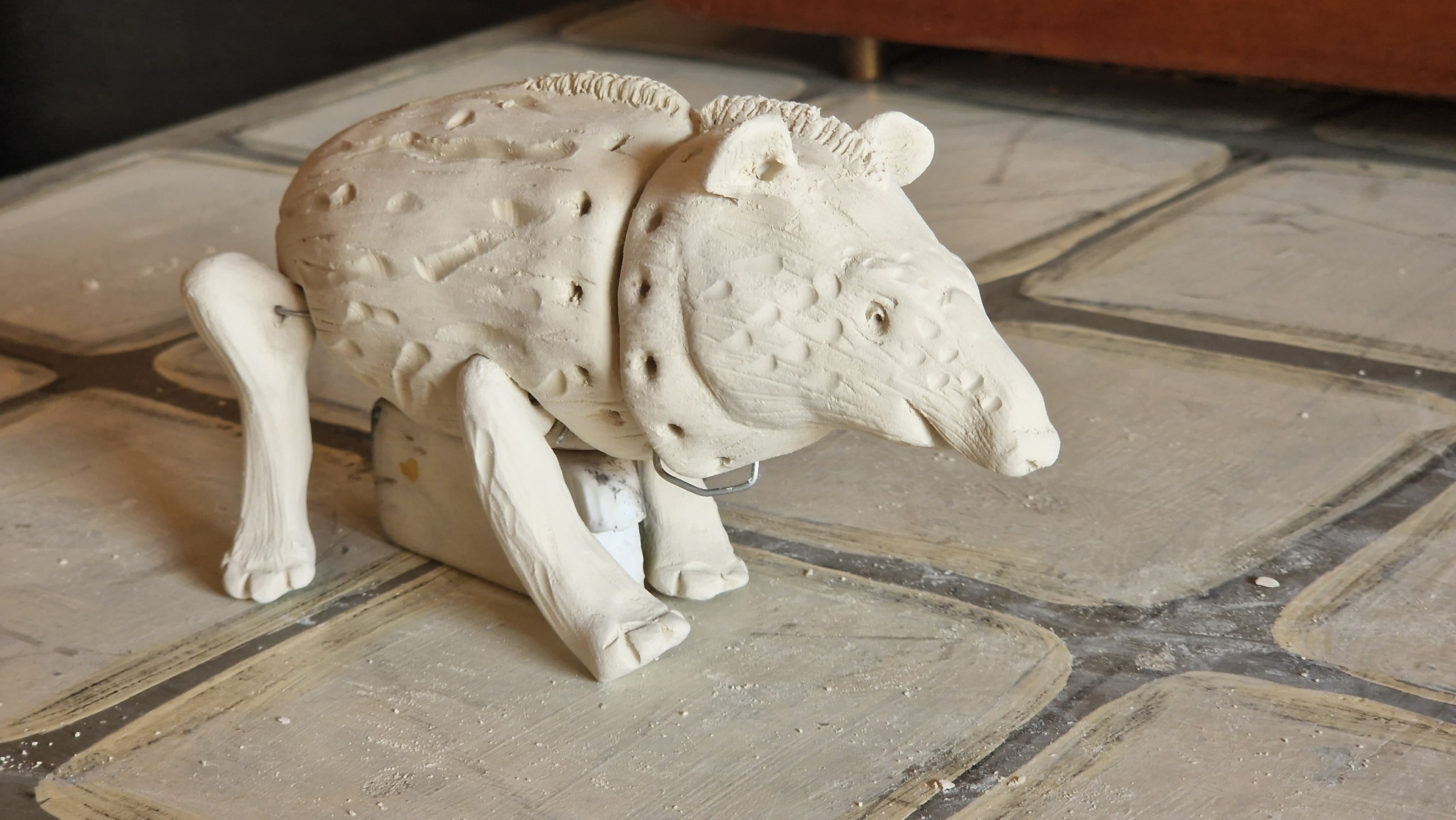 Fotografía. En la imagen se observa una figura de cerámica, similar a un oso hormiguero.