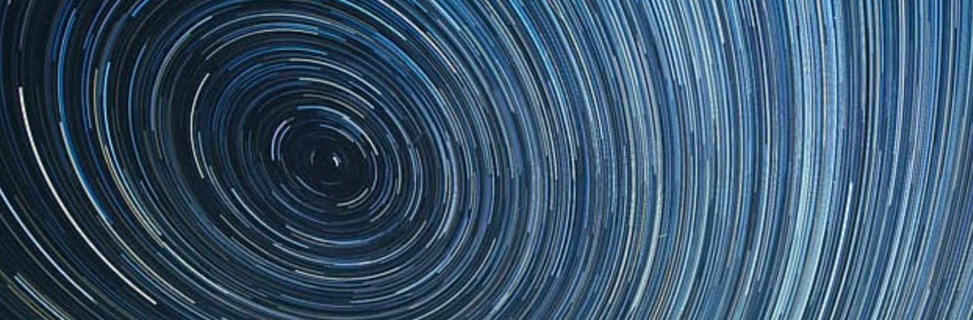Foto. Varias líneas brillantes curveadas muy cerca una de otra formando círculos concéntricos.