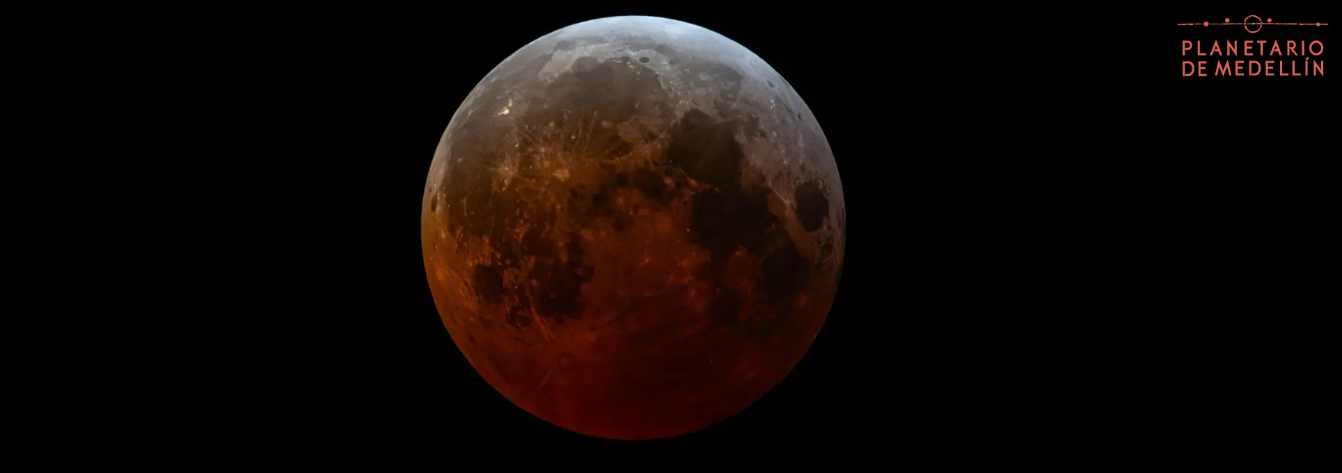 Fotografía de la Luna en tono rojizo sobre fondo negro.