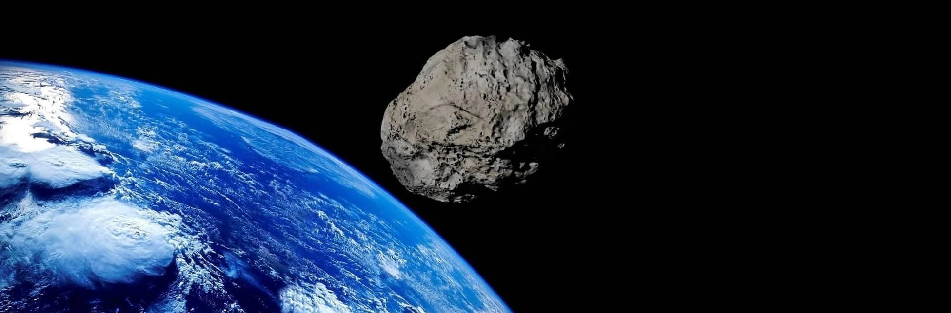 Fotografía del espacio con la Tierra en la parte inferior derecha y un asteroide en el centro.