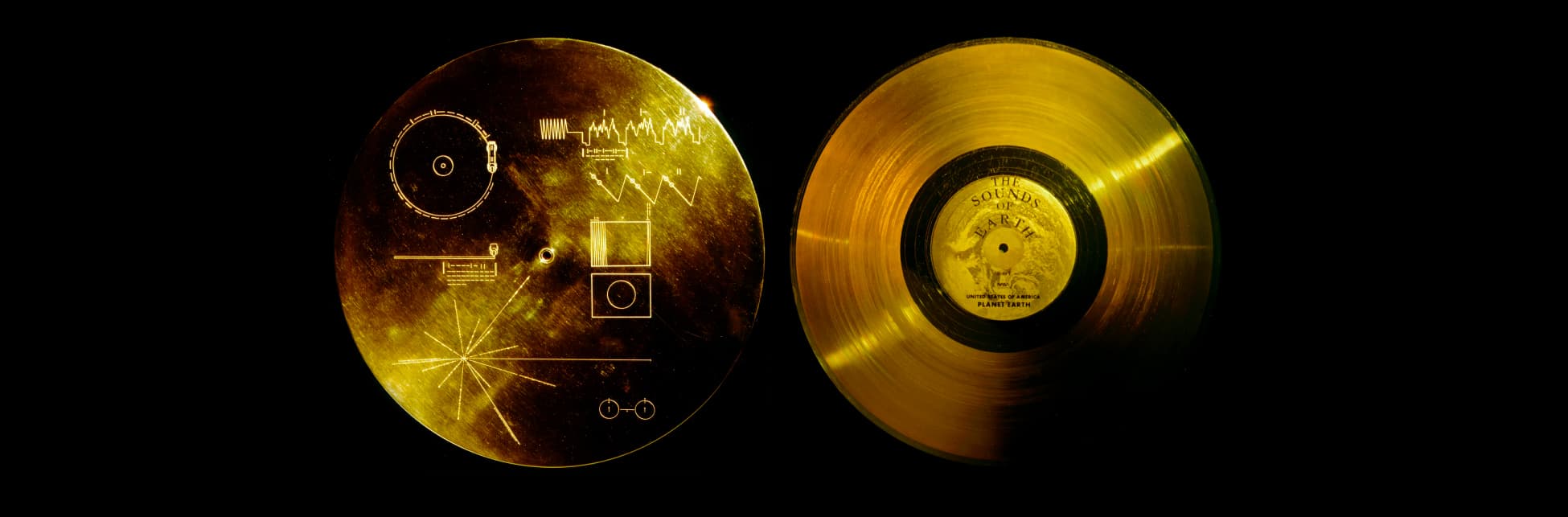 Fotografía. Dos discos dorados con marcas en su superficie sobre un fondo negro.