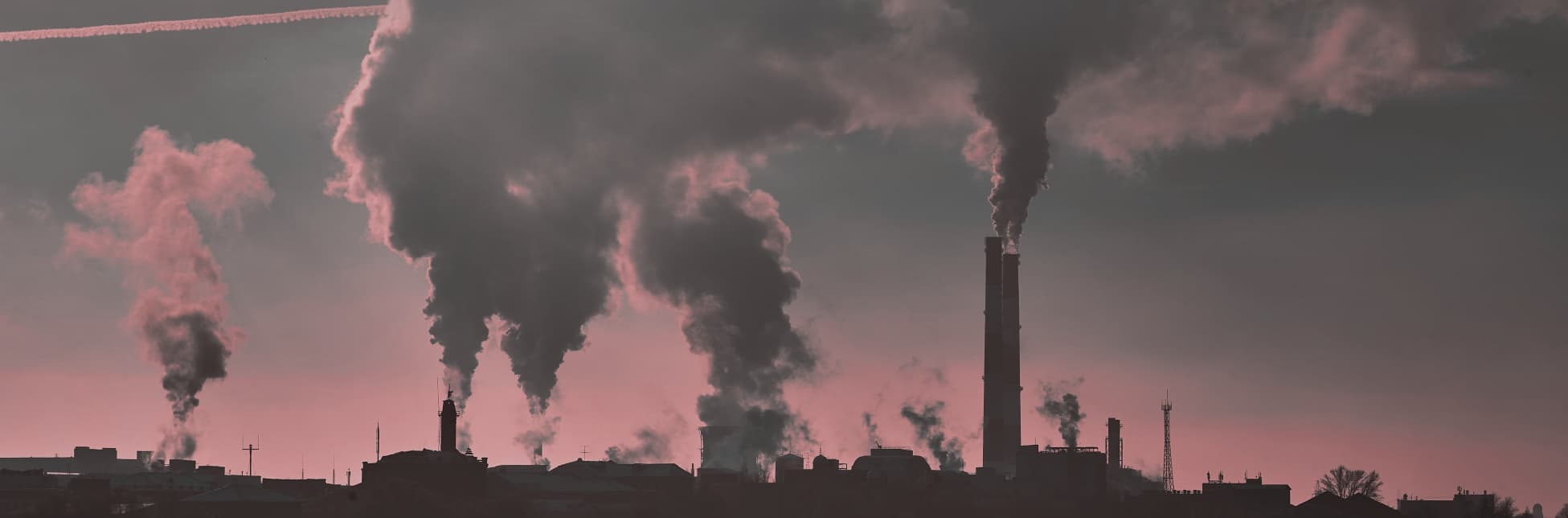 Ilustración. Sobre un fondo fotográfico en tonos rosados y grises se observan chimeneas industriales emitiendo grandes columnas de humo.